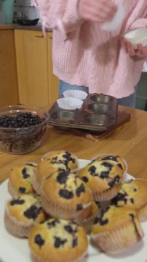 Bir kız sıcak bir mutfakta yabanmersinli kek pişiriyor..