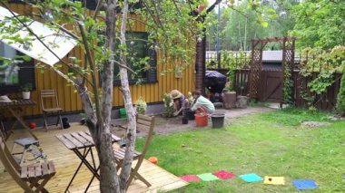 Bir anne ve kız baharda bahçelerine ortanca dikip yaz mevsimine hazırlanıyorlar..