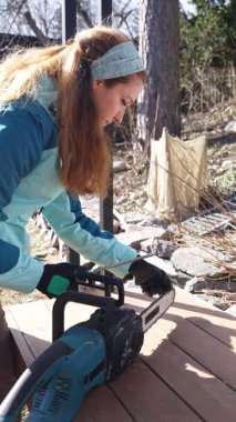 Kararlı bir kadın elektrikli testere bıçağını keskinleştirir, bahçe işi için hazırlanır. Kendi kendine yetebilme ve yetkinliği benimsiyor. Açık hava bakımının herkes için olduğunu kanıtlıyor. Bahar yenilenmesi devrede.