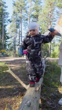 Anne ve çocuk, Fin ormanında birlikte doğa keşfi yaparak yürüyüş yaparlar. Aile gezintisi, doğayla bağlantı. Çevre bilinci ve çevre sevgisi.