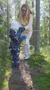 Anne ve çocuk, Fin ormanında birlikte doğa keşfi yaparak yürüyüş yaparlar. Aile gezintisi, doğayla bağlantı. Çevre bilinci ve çevre sevgisi.