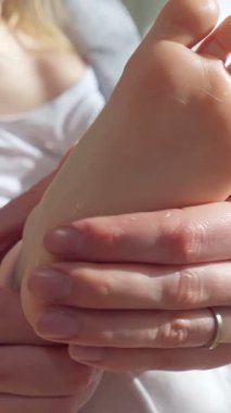 Nemlendirici krem sürerken bir çocuğun ayağına yakın çekim. Yumuşak doğal ışıkta cilt bakımı ve hijyen kavramı.