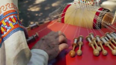 Geleneksel Fin kostümlü bir kadın dantel dantelli, antika dantelli yastıklı ve eski ahşap kürklü.