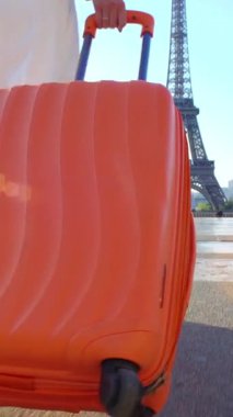 Turuncu Çantayı Paris'e yolculuk ile genç kadın. Eyfel Kulesi arka plan.