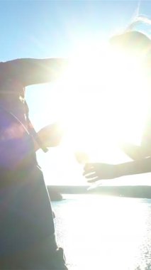 İki mutlu bayan arkadaş göl veya denizin kıyısındaki uçurumun tepesinde bir şişe şampanyayı paylaşıyor, güneşli bir yazın tadını çıkarıyorlar, doğa ve özgürlük.