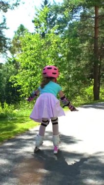 İlk buz pateni. Anne-babalar kızlarının paten kaymayı öğrenmesine yardım ediyor. Yavaş Hareket.