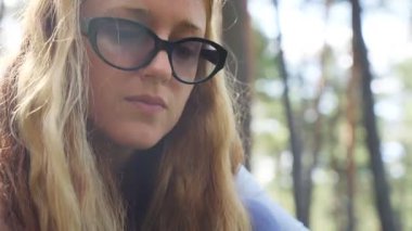 Güneşli bir ormanda yabani böğürtlen arayan genç bir kadın. Çevre yaşam tarzı, sürdürülebilirlik, sağlıklı beslenme, farkındalık ve yaz sonu doğayla bağlantı kavramı.