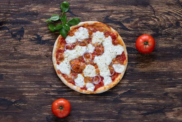 Domates soslu pizza, mozzarella peyniri, kırmızı soğan ve ahşap arka planda taze fesleğen. Üst Manzara. Boşluğu kopyala