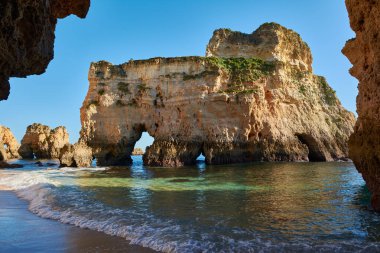 Okyanus tarafından yıkanmış mağaralı kireçtaşı kayası. Algarve, Portekiz