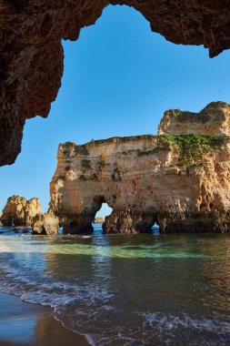 Okyanus tarafından yıkanmış mağaralı kireçtaşı kayaları. Mağaranın manzarası. Algarve, Portekiz