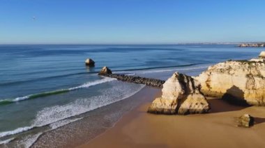 Portekiz, Portimao 'daki ana plaj Praia Da Rocha' da kayaların ve kayalıkların üzerinde uçuyor. 