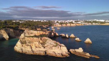 Etrafta uçuşan koca bir martı sürüsü olan kireçtaşı kayaları. Tipik Algarvia manzarası. Portimao, Portekiz