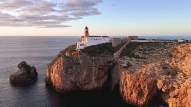 Gün batımında Cabo de Sao Vicente kalesine ve deniz fenerine doğru uçuş. Algarve, Portekiz