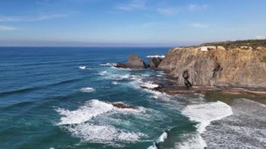 Okyanus dalgaları kayalara çarpıyor. Portekiz 'deki Aldatmaca Mar Plajı