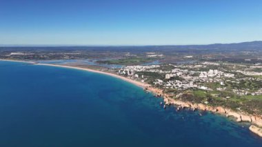 Portekiz kıyı şeridinin geniş açılı drone görüntüleri Alvor ve Portimao 'yu arka planda dağlarla gösteriyor.