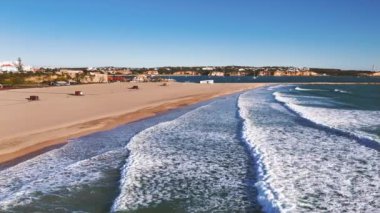 Kışın Portekiz 'de Praia da Rocha üzerinde uçmak. Altında okyanus dalgaları. Alçak mevsimde kumsal bomboş