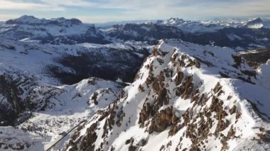 İnsansız hava aracı karla kaplı bir dağ sırtından yükseliyor. Görüntü: Rifugio Lagazuoi, Dolomites, İtalya