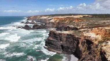 Portekiz 'in batı kıyısındaki yüksek kayalıklara çarpan okyanus dalgalarının manzarası.