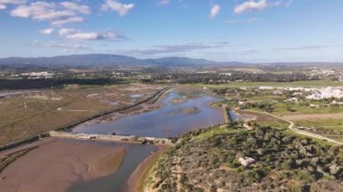 Portekiz 'in baharda Alvor köyü yakınlarındaki nehir, baraj, tarım arazileri ve bataklıkların hava görüntüleri