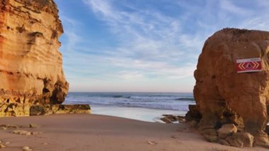 Kırmızı renkli kayalar ve gün batımında Praia dos Careanos plajı. Portimao, Portekiz