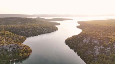Drone uçakları Prokljan Gölü 'nün üzerinde denize ve batan güneşe doğru uçuyor. Krka Ulusal Parkı, Hırvatistan
