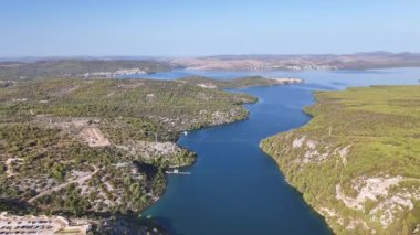 Krka Nehri Prokljan Gölü 'ne akar. Nehrin karşısındaki köprünün havadan görünüşü, yol ve uçurumun kenarından bakış açısı.