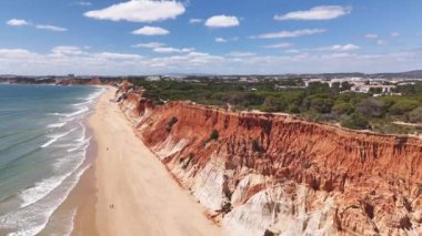 Baharda kırmızı renkli kayalıkları olan ünlü Praia da Falesia plajı. Albufeira bölgesi, Portekiz