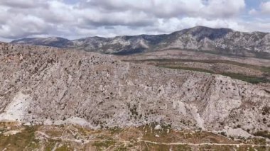 Hırvatistan 'daki Dinaric Alpleri' nin dağ sırasının havadan görünüşü. Drone dağın eteğine yaklaşıyor ve yükseliyor.