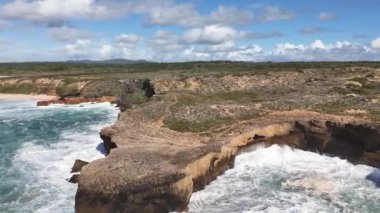 Büyük okyanus dalgaları dik yamaçlara çarpar. Portekiz, Alentejo 'da Balıkçı Yolu