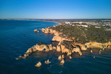 Altın saat boyunca resimli kireçtaşı uçurumları ve Alvor köyünün hava panoramik manzarası. Algarve, Portekiz