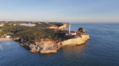 Deniz feneri Farol da Ponta do Altar 'ın günbatımındaki hava manzarası. Ferragudo, Portekiz
