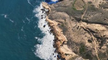 Atlantik Okyanusu 'nun tepe, kum tepeleri ve yürüyüş yollarıyla dolu kıyı şeridinin yukarıdan görünen görüntüsü. Alentejo bölgesi, Portekiz