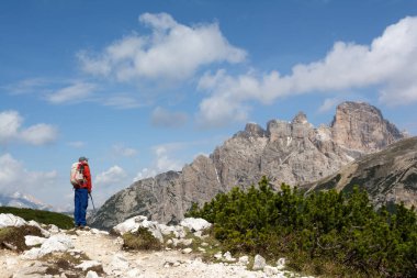 İtalya 'daki Dolomite Alpleri' nde dağlık alp arazisi boyunca yürüyüş yapan bir adam. Aktif yaşam tarzı ve keşif ruhu.