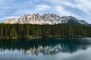 Dolomite Alplerindeki Lago di Carezza 'nın çarpıcı manzarası çevresindeki manzarayı yansıtıyor. Su, orman ve dağın ahenkli bir karışımı ile dokunulmamış doğa.