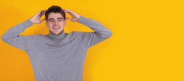 Kolları havada gülümseyen genç adam arka planda tek başına.