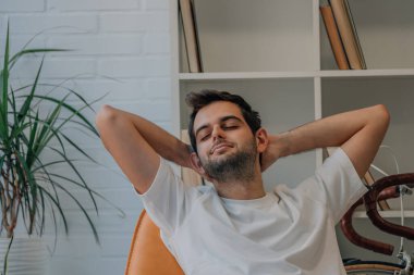 Evdeki adam kanepede dinleniyor.