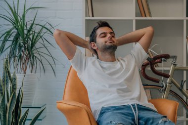 Evdeki adam kanepede mutlu bir şekilde dinleniyor.