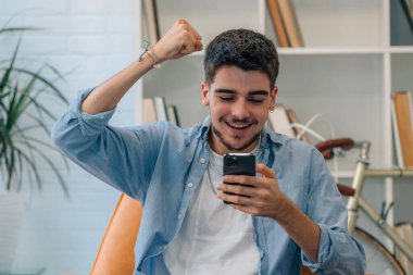 Genç milenyum ya da evde cep telefonuyla kutlama yapan öğrenci.