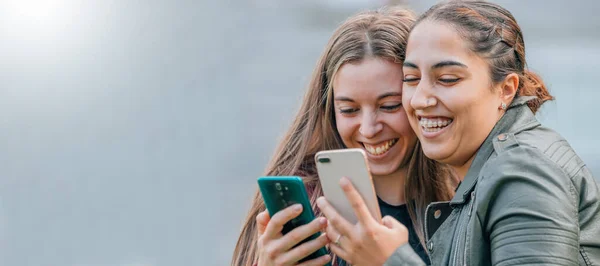 Přátelé Mobilními Telefony Usmívají Objímání Ulici — Stock fotografie