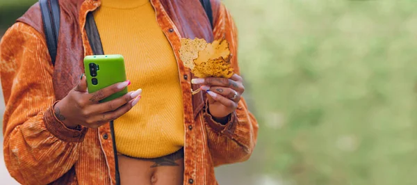 Zbliżenie Rąk Pomocą Telefonu Komórkowego Lub Smartfona Jesiennymi Liśćmi — Zdjęcie stockowe