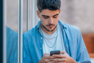 cep telefonu olan genç bir çocuk ya da öğrenci