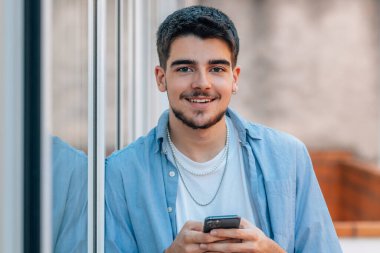 cep telefonu olan genç bir çocuk ya da öğrenci