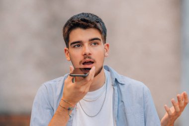 Genç adam sokakta sesli mesaj yolluyor.