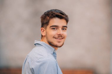 Sokakta sakallı, gülümseyen, çekici, beyaz bir adam.