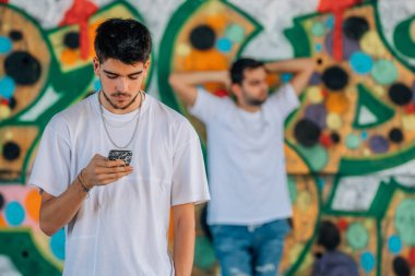 Sokakta cep telefonu olan bir grup genç.