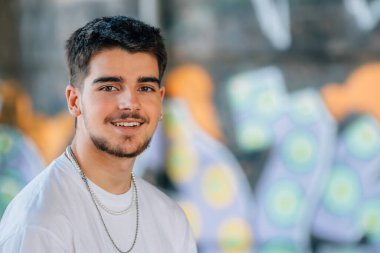 Kameraya bakan sakallı genç bir adamın portresi.