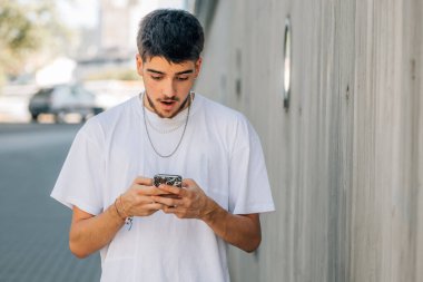 Milenyum ya da öğrenci sokakta cep telefonuna şaşkınlıkla bakıyor.