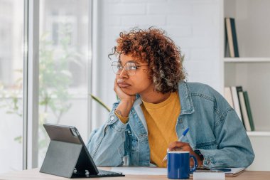 Evde dizüstü bilgisayarı olan, çalışan, düşünen ya da stresli bir kadın.