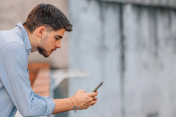 Joven Mirando Teléfono Móvil Calle — Foto de Stock