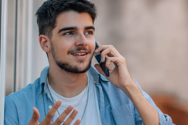 young millennial or student talking on the phone in the street